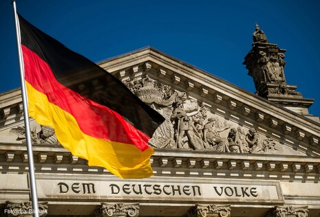 Deutschlandfahne vorm Reichstag in Berlin